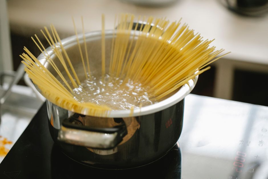 Panela com água e açúcar sendo aquecida no fogão para fazer calda