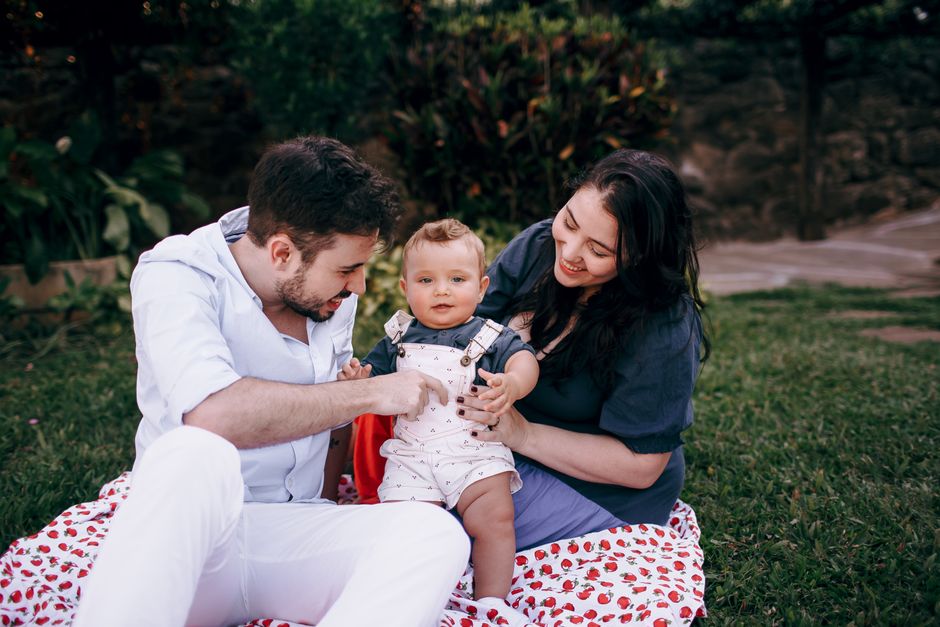 Família fazendo piquenique na primavera sobre toalha no jardim