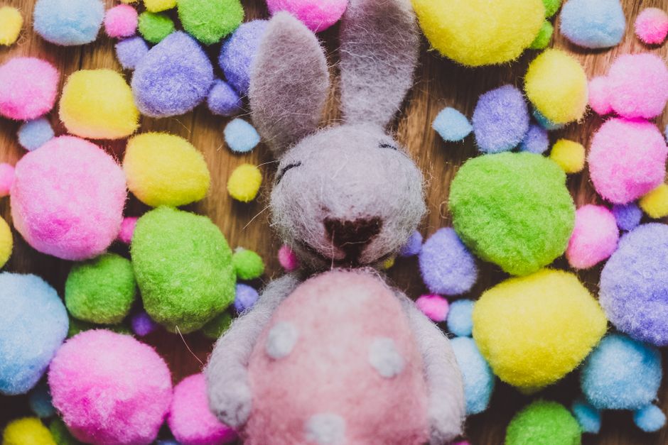 Criança usando pregador de roupa para pegar pompons coloridos e colocar em uma tigela