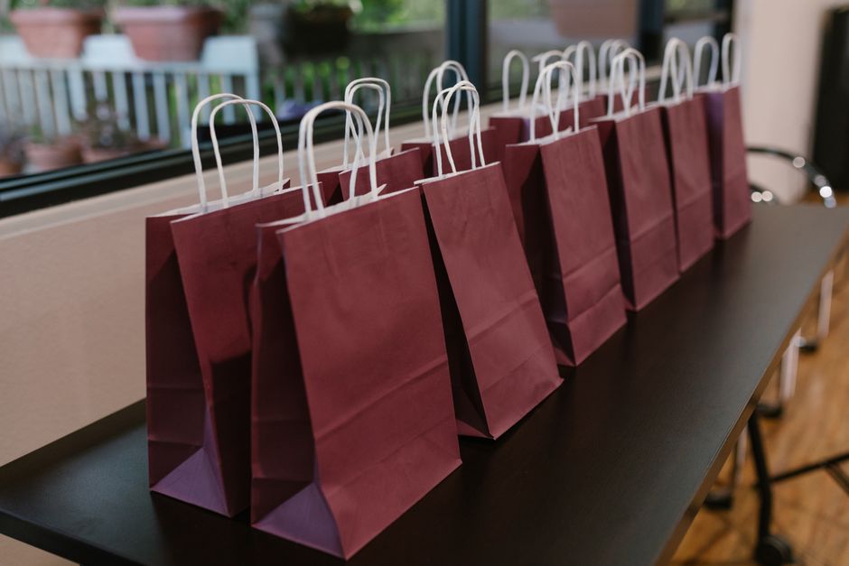 Sacolinhas de papel kraft de lembrancinha alinhadas sobre a mesa da festa