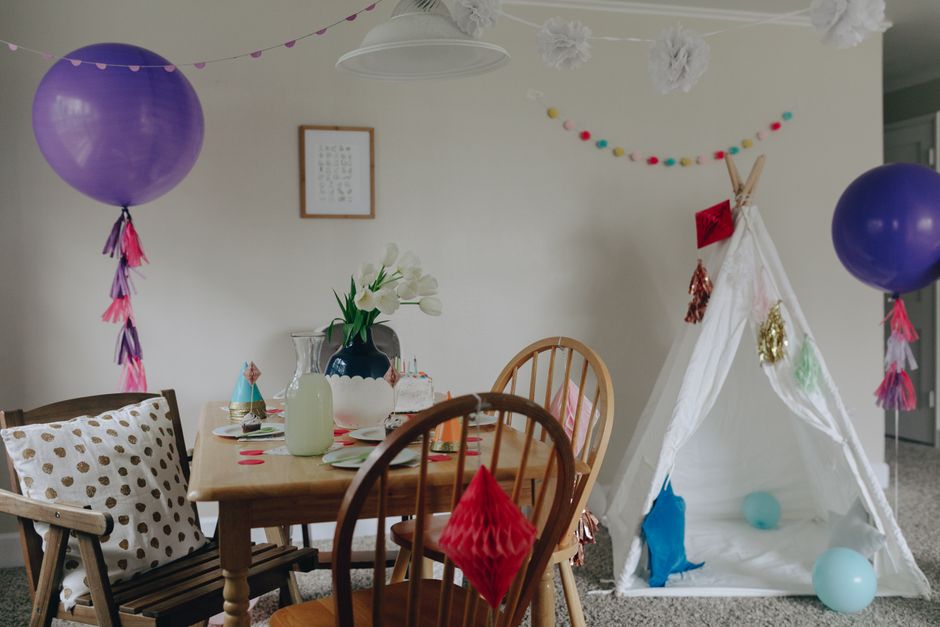 Água-viva feita com balão roxo e fitas de papel crepom pendurada na decoração