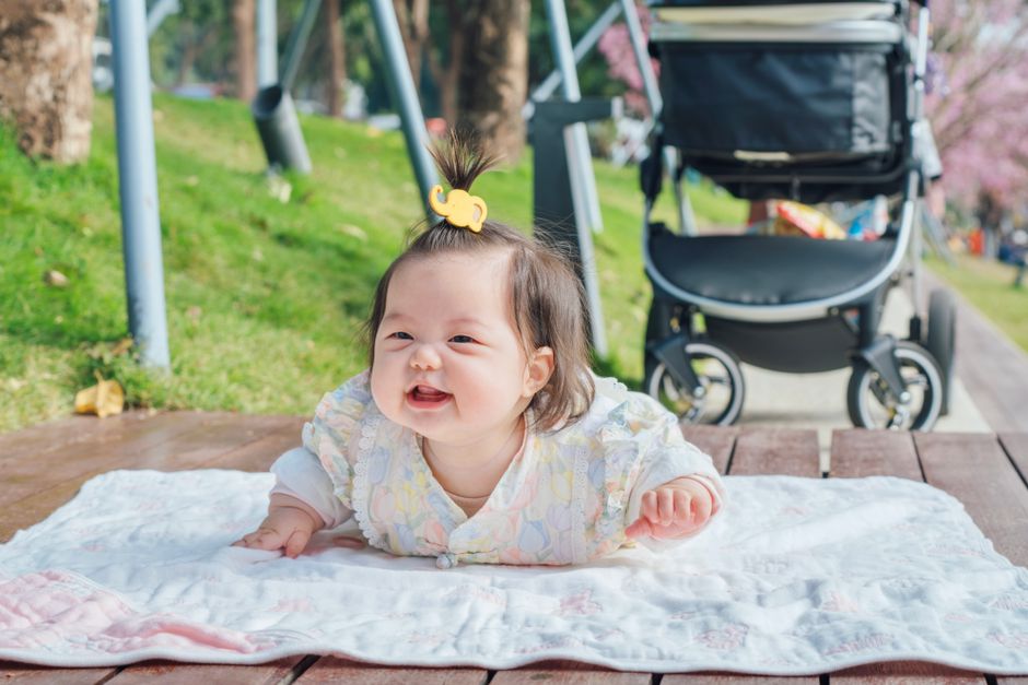 Bebê sorrindo durante brincadeira de bruços
