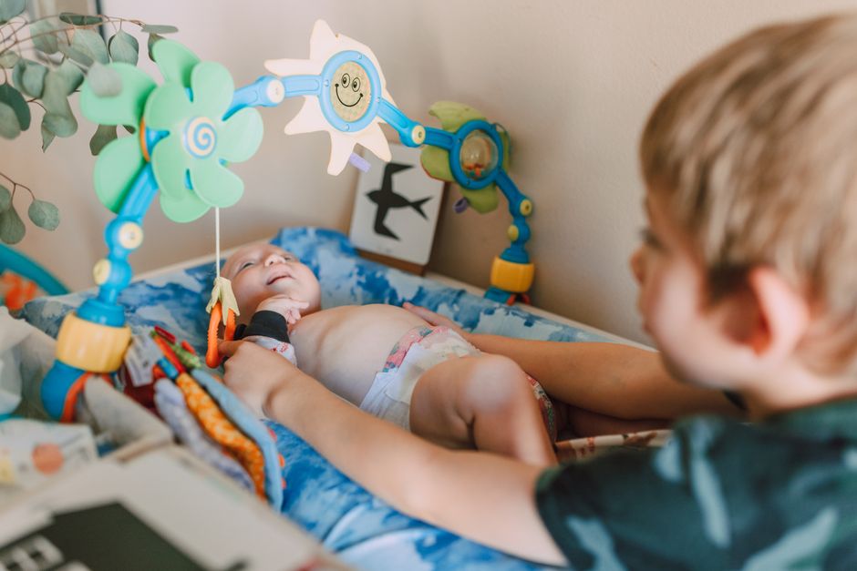 Irmão mais velho brincando e interagindo com a bebê mais nova